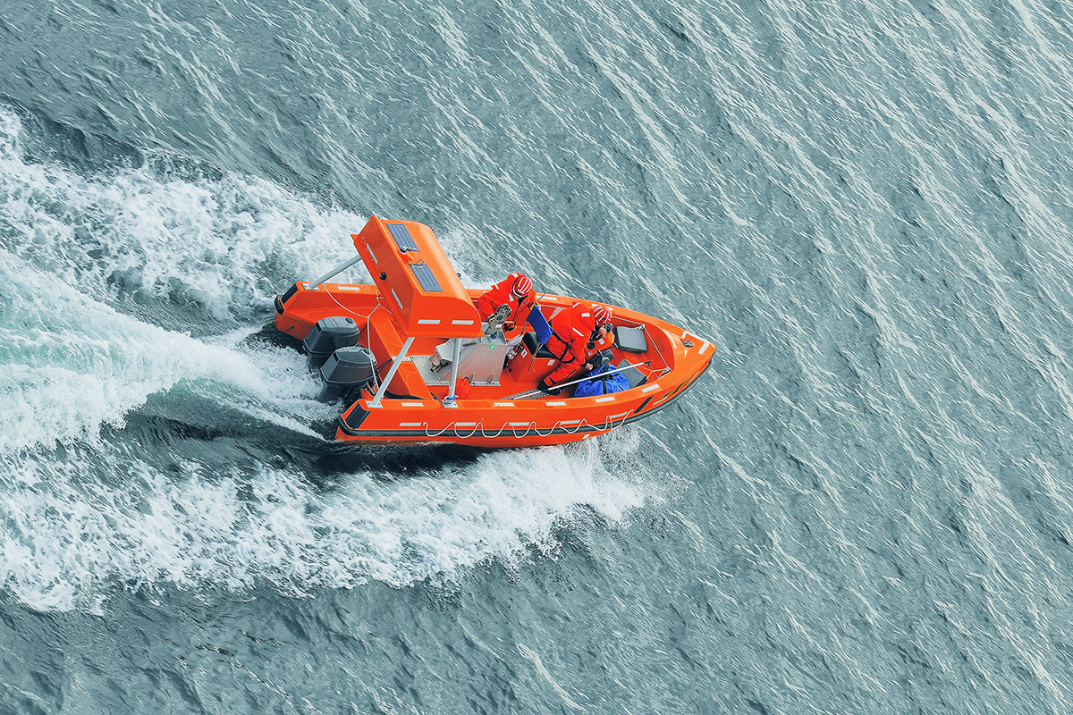 An aerial photo of a boat driving on the water.